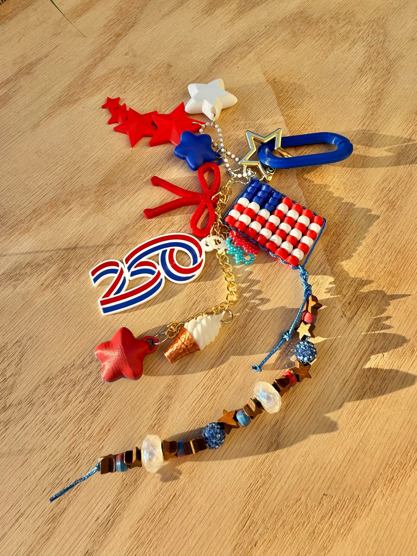 Bag charm with various charms including a flag, stars, and numbers on a wooden surface